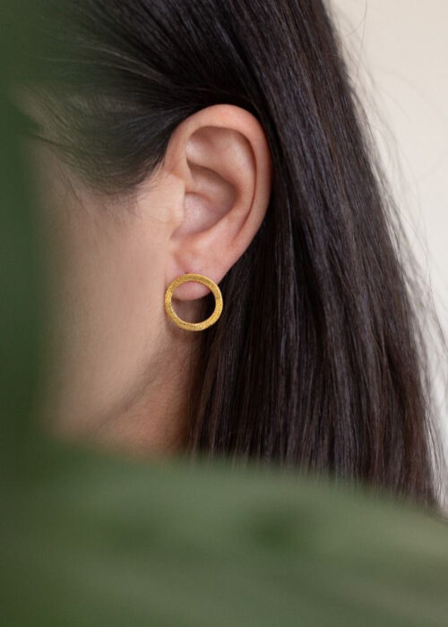 Model mit Ohrringen Cira in gold